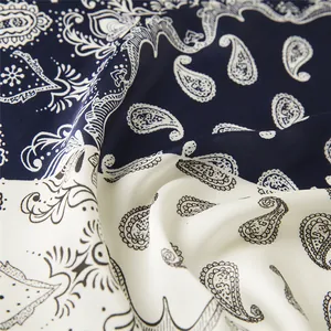 Detailed macro view of smooth faux silk fabric with navy and white paisley patterns