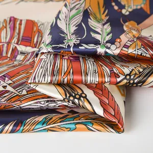 Detail of bohemian silk scarf with vibrant feather patterns and smooth satin luster