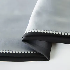 Detailed view of silver grey satin silk scarf with black geometric border and white dots