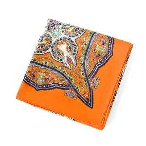Detail eines Seidenschals mit Paisley-Muster und floralen Blättermotiven in Orange