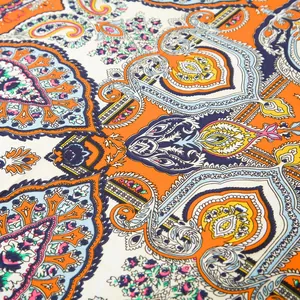 Makroaufnahme des bunten Paisley-Musters auf dem Seidenschal mit orange-blauen Details