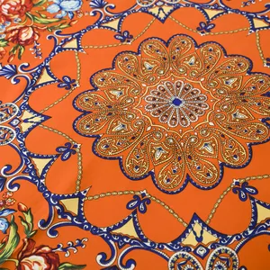 Detailed close-up showing complex bohemian paisley patterns on orange square scarf fabric