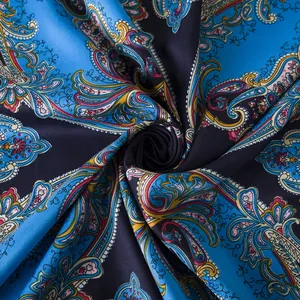 Macro detail of silk scarf showing paisley pattern with satin texture and vibrant colors