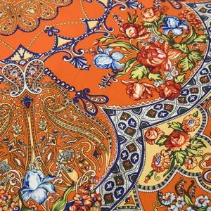 Detailed macro view of bohemian paisley and floral print on large orange silk scarf