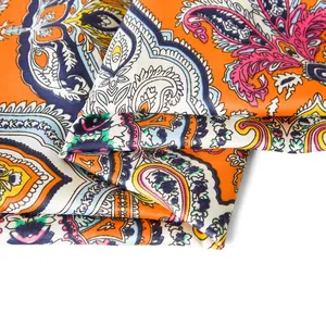Detailansicht eines orangefarbenen Seidentuchs mit Paisley-Muster und Köperbindung