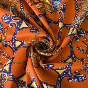Close-up of bohemian silk scarf with orange paisley patterns and fine twill texture