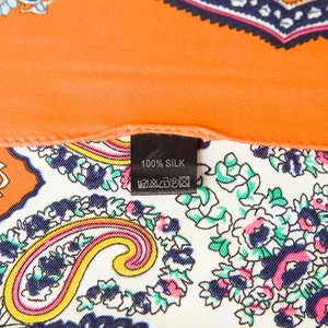 Detailansicht eines Seidenschals mit Paisley-Muster und orangefarbenem Blumendruck