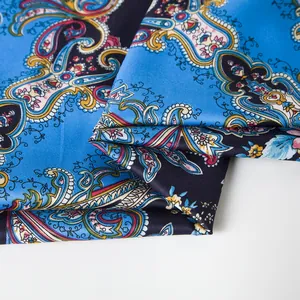 Detailed view of paisley patterns and smooth satin texture on the royal blue silk scarf