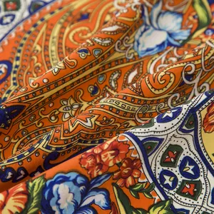 Close-up of bohemian orange scarf with intricate paisley and floral twill pattern