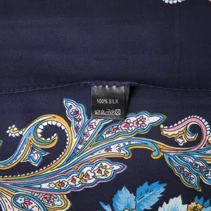 Detailed macro view of 100% silk fabric with paisley rose pattern and washing label