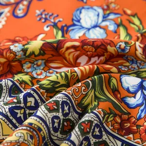 Macro detail of Bohemian floral silk scarf with vibrant orange and blue paisley patterns