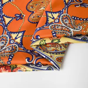Detailed macro view of orange paisley floral scarf with luxury silk twill texture