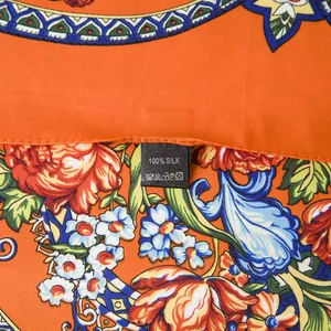 Close-up of 100% silk scarf with floral patterns and luxury twill texture detail