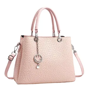 Borsa a mano rosa chiaro intrecciata con ciondolo smiley argento e tracolla reg.