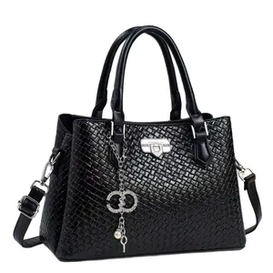 Large black woven handbag with silver twist lock and pearl charms on white background