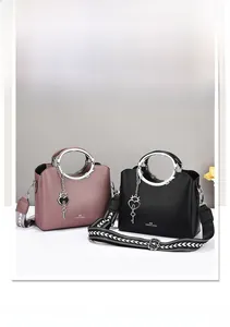 Detail of elegant tote bags with silver ring handles, heart charms, and wide floral straps