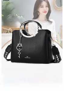 Detail of black pebble leather tote with silver metal handles and geometric pattern strap