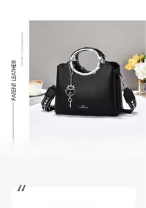 Detail of black pebbled leather tote with silver round handle and embroidered strap