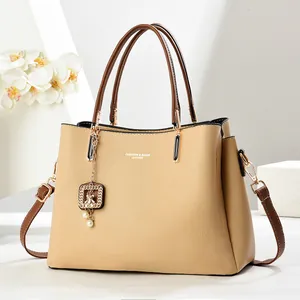 Détail du sac à main beige élégant avec anses marron et décoration florale