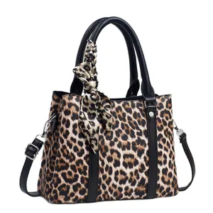 Classic leopard print handbag with silk scarf detail and adjustable black shoulder strap