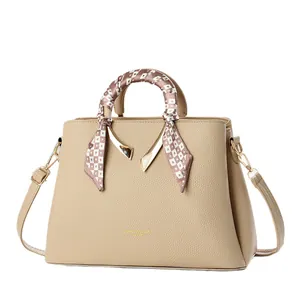 Beige faux leather handbag with textured finish, gold hardware, and patterned silk scarf
