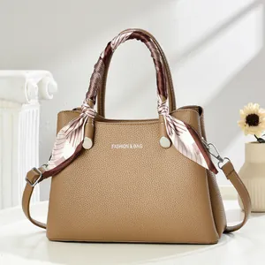 Elegant brown lychee leather handbag for women with decorative silk scarf and shoulder strap