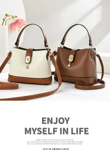 Detail of minimalist contrast bucket bags with lychee grain leather and golden hardware