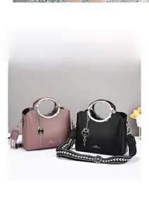 Detail of pink and black tote bags with metal ring handles and woven guitar straps