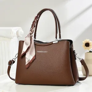 Detail of dark brown lychee leather tote bag with silk scarf and fashion text