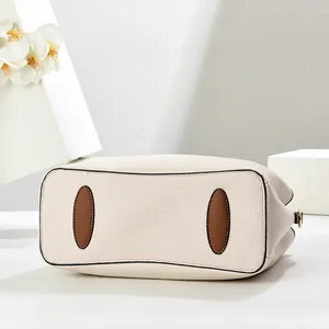 Vue détaillée du fond de sac crème avec patchs de protection en cuir marron