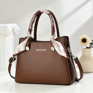 Elegant dark brown leather tote bag with silk scarf handle and silver metal hardware