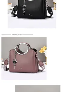 Detail of lychee pattern leather tote with metal ring handle and woven wide strap
