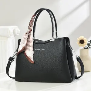 Detail of black lychee grain leather tote bag with silk scarf and silver hardware