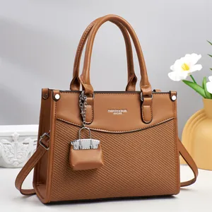 Elegant dark brown tote bag with woven texture, silver hardware and a mini charm