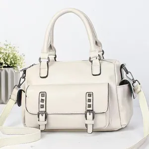 Chic cream leather underarm bag with metal rivets and adjustable shoulder strap