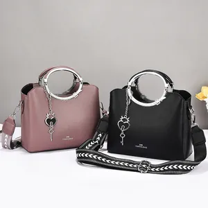 Fashionable women's shoulder bag with round metal handles and patterned wide strap