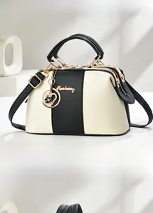 Détail du sac cabas contrasté avec ferrures dorées et pendentif fleur en cœur