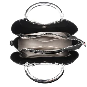 Top view of a black pebbled leather tote bag with silver handles and chevron lining