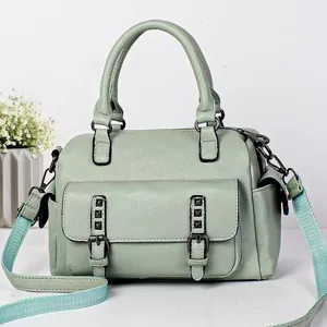 Mint green pebble leather Boston handbag with adjustable woven strap and front pocket