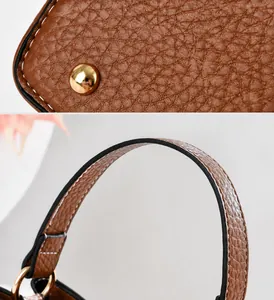 Close-up of bottom protective rivets and fine edge stitching on brown leather bucket bag