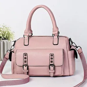 Close-up of pink lychee leather handbag with metallic rivet details and floral decor