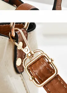 Detail view of leather texture, precise stitching and gold metal buckle of the bucket bag