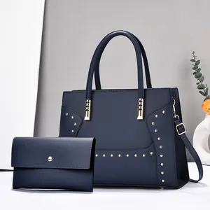 Ensemble sac à main bleu marine avec clous dorés et pochette assortie, vue de face