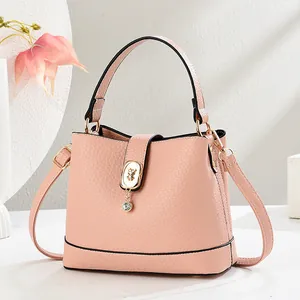 Sac seau rose élégant avec texture litchi, fermoir ours doré et bandoulière amovible