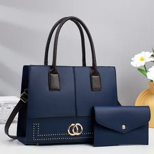 Minimalist navy blue tote bag set with brown handles and gold hardware details