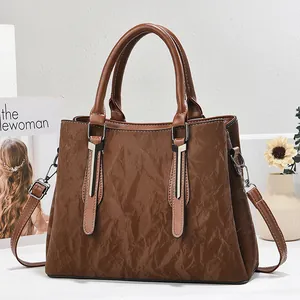 Brown vintage pleated leather tote bag with top handles and adjustable shoulder strap