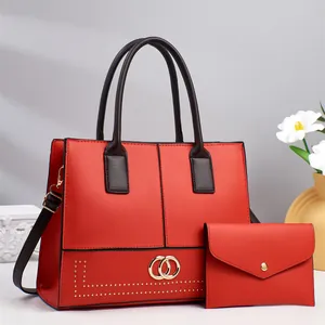 Red structured faux leather handbag set with gold buckle and matching small clutch bag