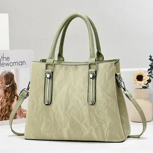 Light green pleated leather handbag with silver hardware and adjustable shoulder strap