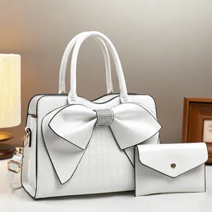 White crocodile pattern bucket bag with oversized bow and matching envelope wallet