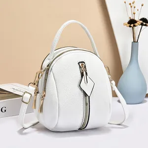 Elegant white pebbled leather mini crossbody bag with triple zipper and gold hardware